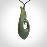 This picture shows a hand carved jade koru pendant. It is a deep green colour and is a wonderful, large sized piece of jewellery. The cord is a four plait black colour and adjustable so that you can position the pendant where it suits you best. This koru was carved for us by Ric Moor. Delivery is free worldwide.